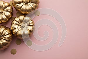 Beautiful golden pumpkins on pastel pink. Flat lay thanksgiving composition