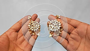 Beautiful Golden shiny Vintage gold pearl metal earrings hand showing