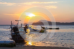 beautiful golden sunrise above fishing boats in Rawai beach