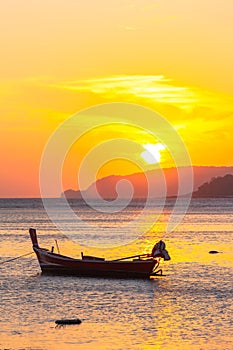 Beautiful golden sunrise above fishing boats in Rawai sea