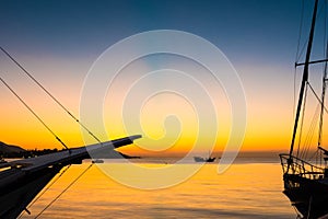 Beautiful golden sunset and blue sky over sea with boat in summer.