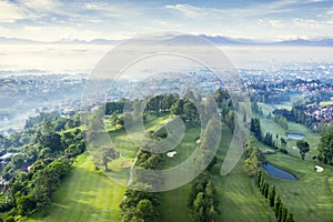 Beautiful golf course with misty Bandung cityscape photo