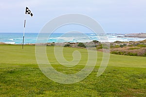 Beautiful golf hole green with flag on California ocean coast