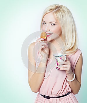 Beautiful gorgeous blonde girl with bright makeup in pink dress in the Studio on a white background sitting