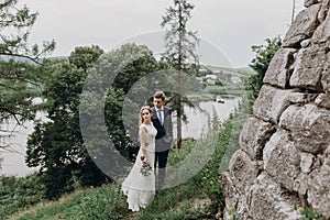 Beautiful gorgeous bride and groom posing. happy wedding couple hugging and embracing at old castle. happy romantic moments.