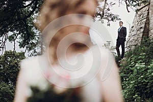 Beautiful gorgeous bride and groom posing outdoors. happy wedding couple embracing at old castle. happy romantic moments.