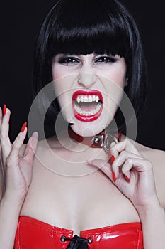 Beautiful gothic brunette with vampire fangs screaming