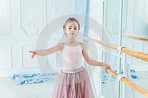 Beautiful graceful ballerina practice ballet positions in pink tutu skirt in dance class
