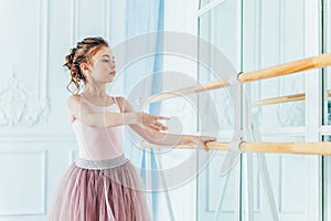 Beautiful graceful ballerina practice ballet positions in pink tutu skirt in dance class