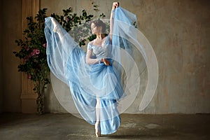 Beautiful graceful girl ballerina in blue dress dancing in point