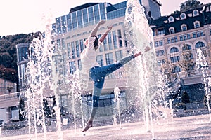 Beautiful graceful woman dancing in the fountain