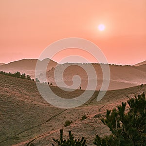 Beautiful grass-covered hills and valley captured under the sunset