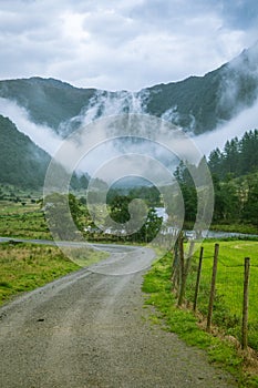 A beautiful gravel road leading into a valley of Rosendal in Folgefonna National park, Norway. Landscape of a overcast autumn day.