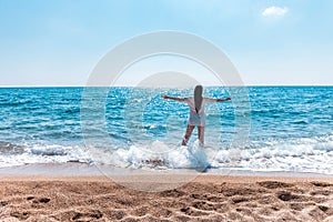 Beautiful greek young brunet woman on beach in white dress