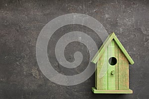 Beautiful green bird house on grey background, space for text