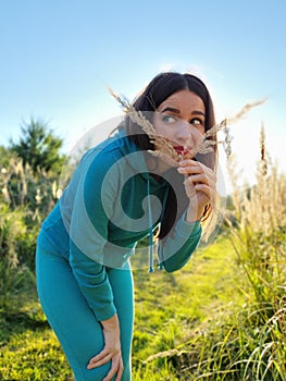 A beautiful girl in a field playing with plants. The concept of walking in nature, freedom and an eco-friendly lifestyle