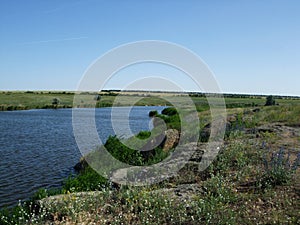 Beautiful green field with hills near the lake