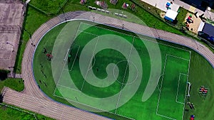 Beautiful green football stadium. Teenagers play football. Football field from a bird`s flight.