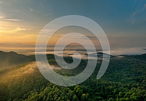 Beautiful green mountain landscape with morning sunrise sky and fog. Aerial view of green trees in tropical mountain forests and