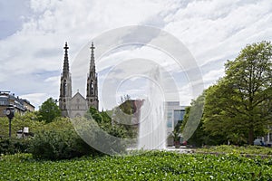 Green park with a fountain, next to the Evangelical Church in Europe, augustaplatz and fountain in Baden Baden photo