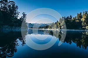 Beautiful green scenery reflecting in  Lake Matheson, New Zealand