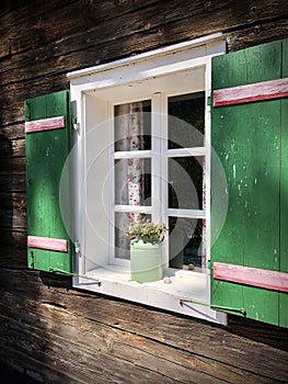 Beautiful green shutters and white window on typical and traditional austrian alpine wooden house - Salzkammergut