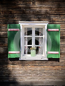 Beautiful green shutters and white window on typical and traditional austrian alpine wooden house - Salzkammergut