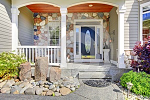 Beautiful grey new classic home entrance exterior with natural stone.