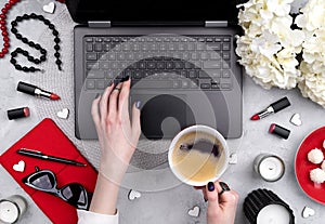 Beautiful groomed woman`s hands typing at keyboard on the home office table