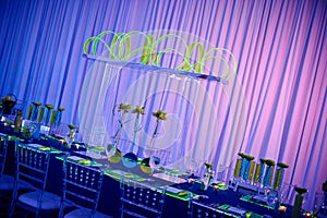 Beautiful guest long table set up for a wedding or social event in the ballroom orchid and lucite center piece green and red photo