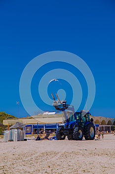 White seagulls flying in the blue summer sky and tractor