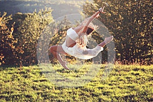 Beautiful gymnast in a difficult jump outdoor