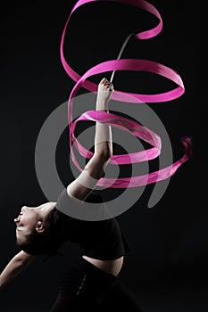 Beautiful gymnast with pink ribbon