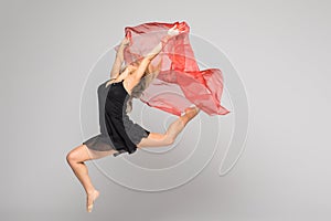 Beautiful gymnastics dancer on aerial silk in studio on white background.