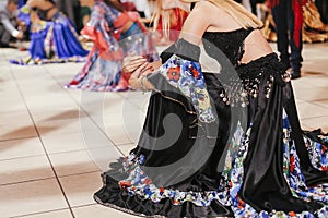 Beautiful gypsy girls dancing in traditional colorful clothing. Roma gypsy festival. Woman performing romany dance and singing