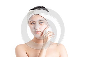 Beautiful half naked model young woman applying cosmetic cream treatment on her face isolated on white background. Skincare and