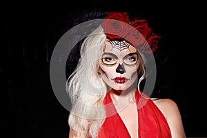 Beautiful Halloween Make-Up Style. Blond Model Wear Sugar Skull Makeup with Red Roses. Santa Muerte concept