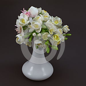 Hand made polymer clay flower bouquet in a white vase on a dark photo
