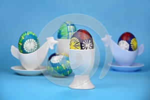 Beautiful hand painted easter eggs in ceramic egg cup holder stock images