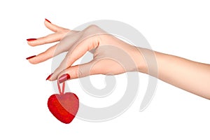Beautiful hand with red manicure holding red heart. photo