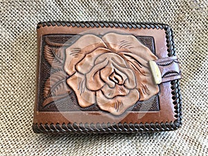 Beautiful Hand Tooled Leather Wallet with Lacing and Rose Design On Burlap Background