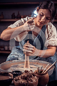 Beautiful handicraftsman making ceramic pot on the pottery wheel . Craft manufacture.