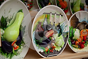 Beautiful handmade plate with voluminous vegetables and sculpted food painted on it. nobody.