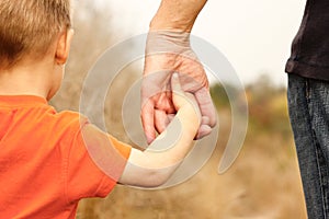 Beautiful hands of a happy child and parent in the nature park photo