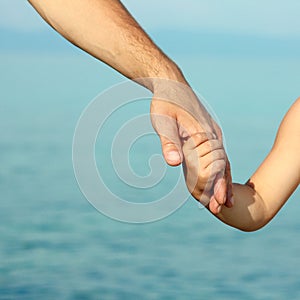 beautiful hands of parent and child by the sea