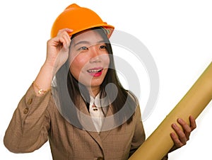 Beautiful and happy Asian Chinese woman in hardhat holding building blueprints as architect engineer or constructor supervisor in