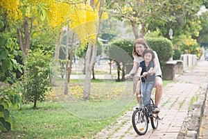 Asian mother and son riding bicycle