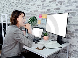 Beautiful happy Asian woman working with laptop computer in her room, condominium
