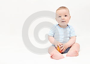 Beautiful happy baby boy sitting with apple