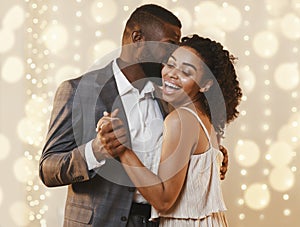 Beautiful happy black couple dancing in modern restaurant